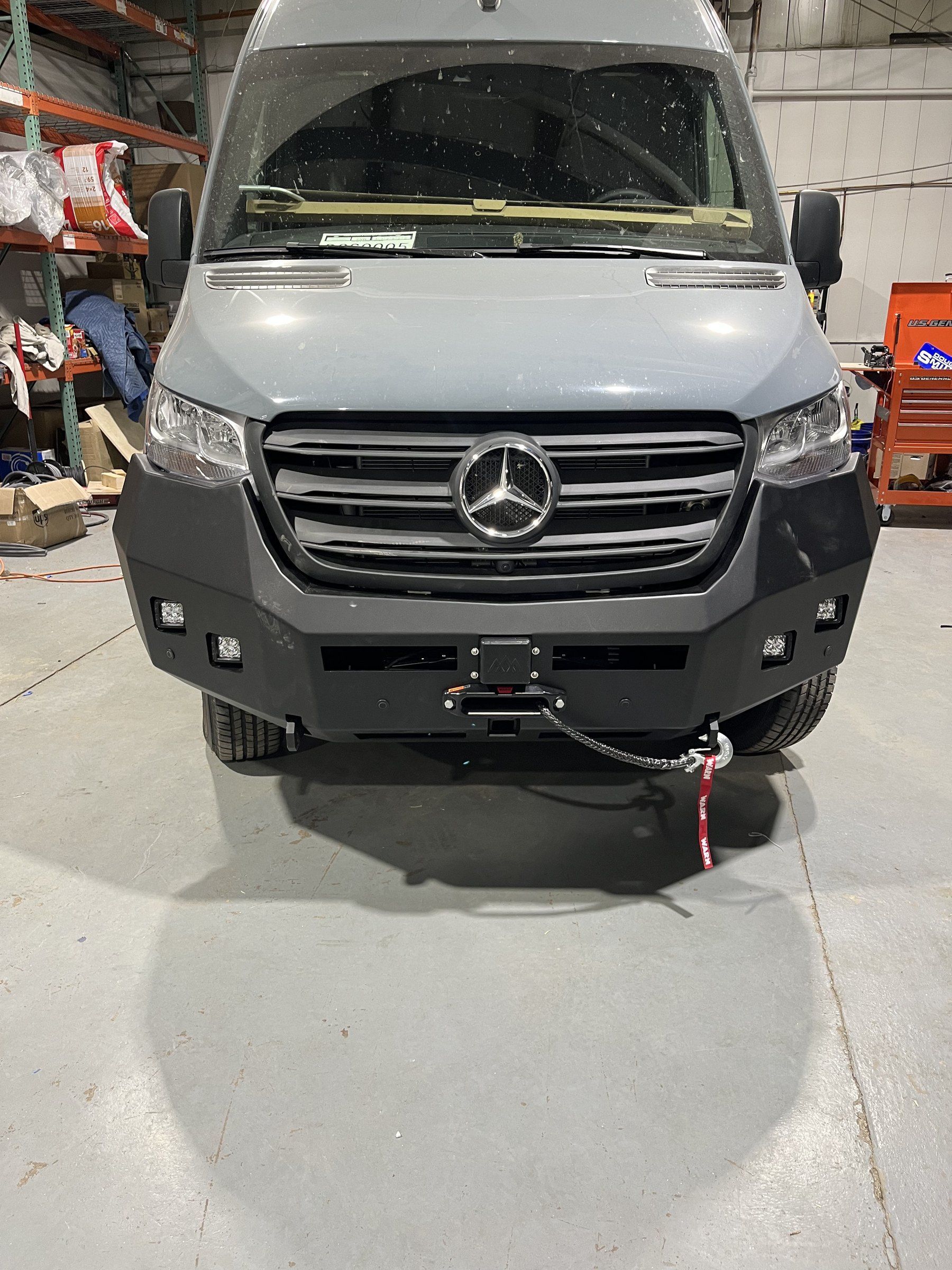 Front of the van in the shop with the Backwoods bumper and Warn winch.