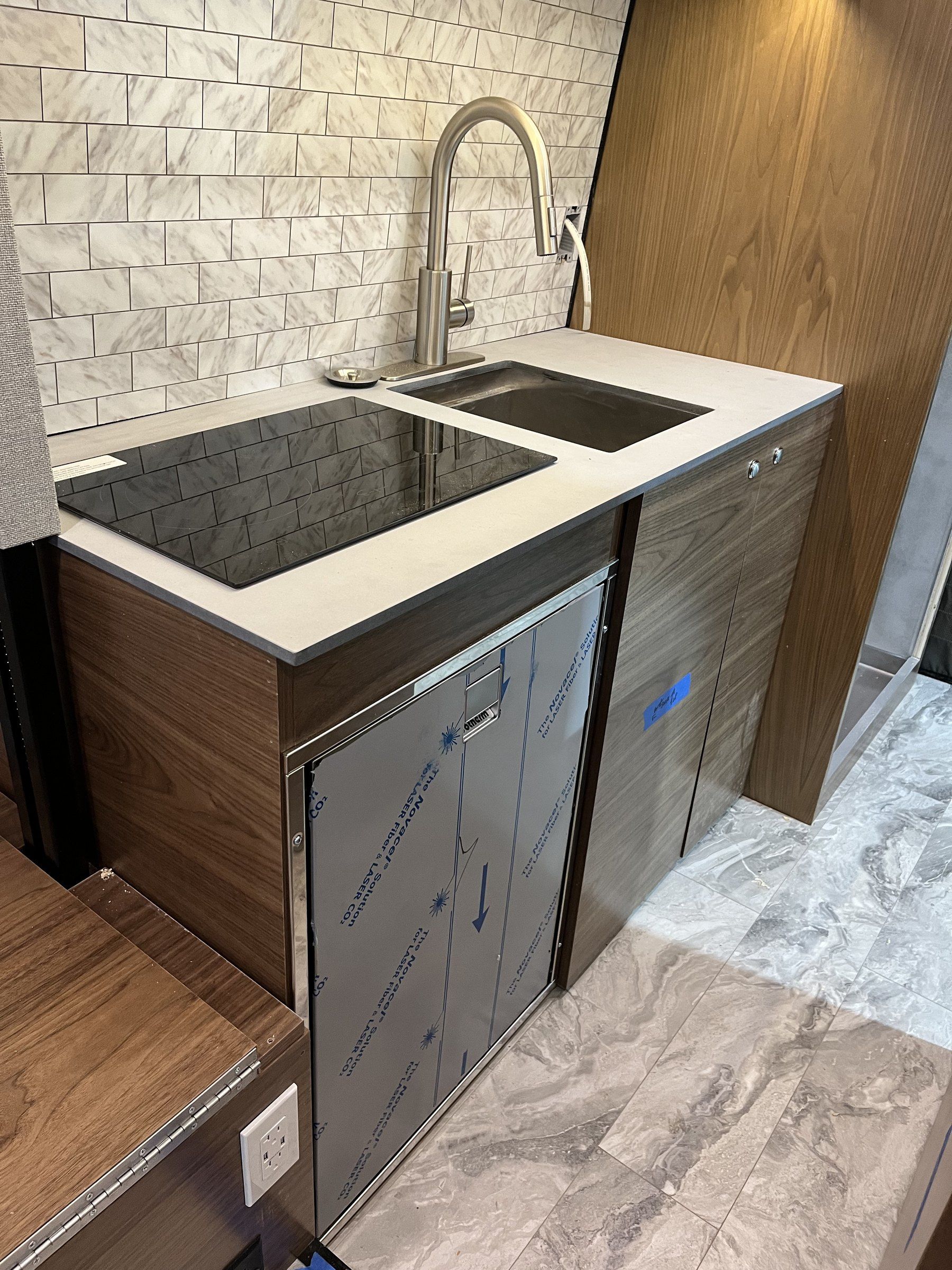 Galley cabinets with fridge, sink and cooktop during fit-out.