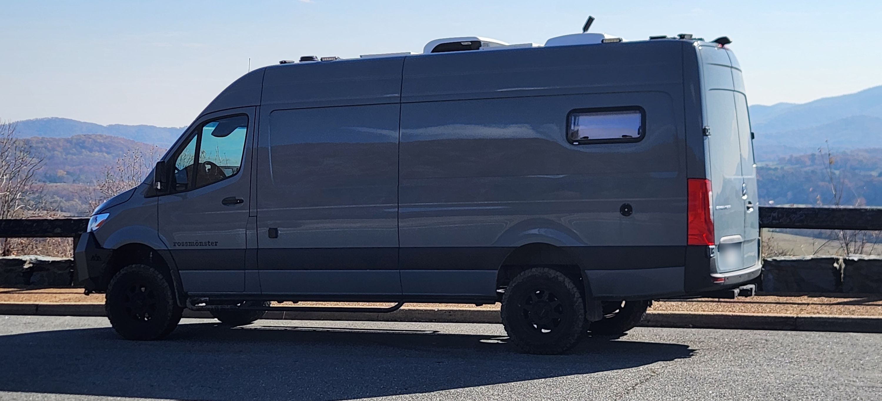 The van broadside at a Blue Ridge overlook in Virginia, mountains behind it.